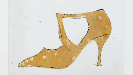 Ein goldener Damenschuh auf weißem Hintergrund
