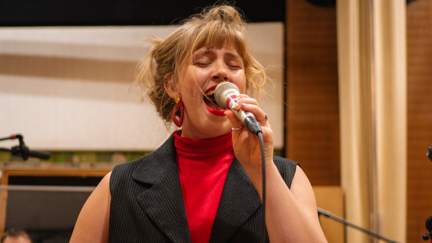 Eine singende Frau, Carla Kaltenböck, mit Mikrofon